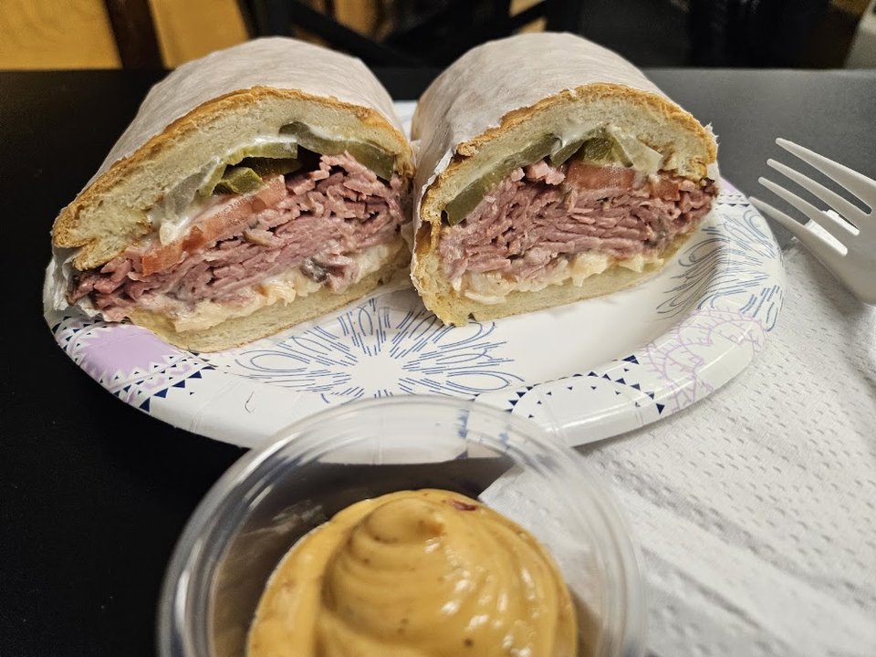 Printed menu with sandwiches and side dishes.
